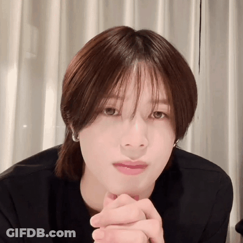 A Close Up Of A Person 'S Face With Their Hands Folded In Front Of Their Face GIF