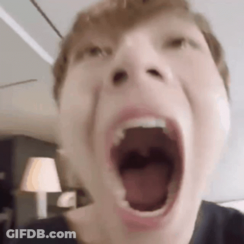 A Close Up Of A Person 'S Face With Their Mouth Wide Open . GIF