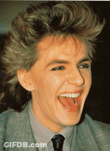 A Close Up Of A Person 'S Face With Their Tongue Sticking Out GIF