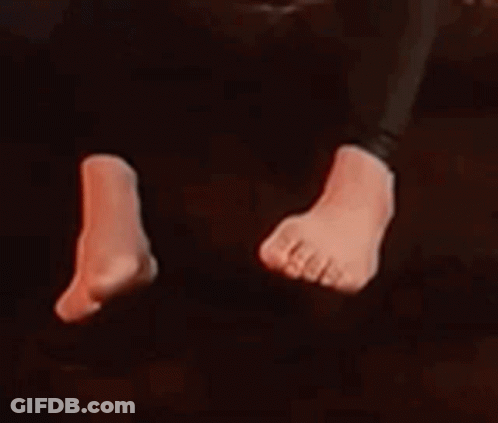 A Close Up Of A Person 'S Feet In A Dark Room With Red Lights . GIF