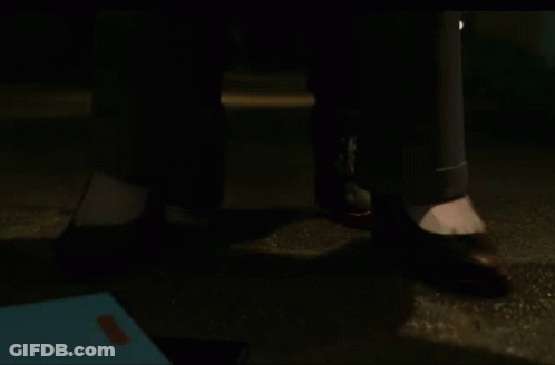 A Close Up Of A Person 'S Feet Standing On The Ground At Night . GIF