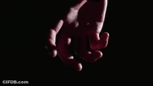 A Close Up Of A Person 'S Fist In A Black Glove GIF