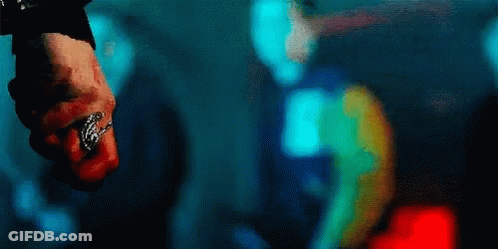 A Close Up Of A Person 'S Fist With A Ring On It In A Dark Room . GIF