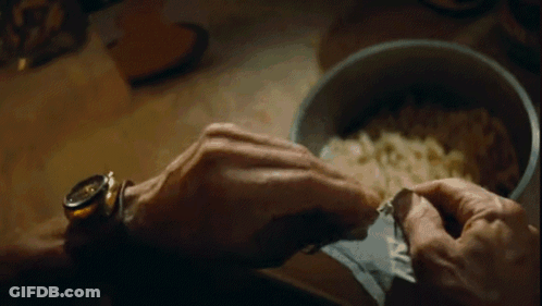 A Close Up Of A Person 'S Hand Holding A Bowl Of Food . GIF