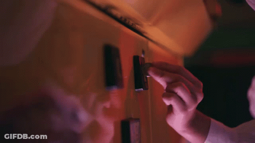 A Close Up Of A Person 'S Hand Holding A Lighter In A Dark Room GIF