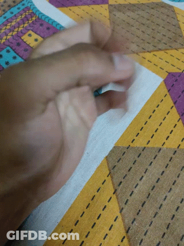 A Close Up Of A Person 'S Hand On A Colorful Fabric GIF