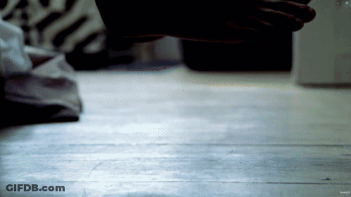 A Close Up Of A Person 'S Hand On A Wood Floor GIF