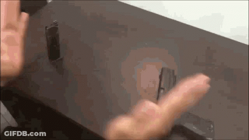 A Close Up Of A Person 'S Hand Reaching For Something On A Table GIF