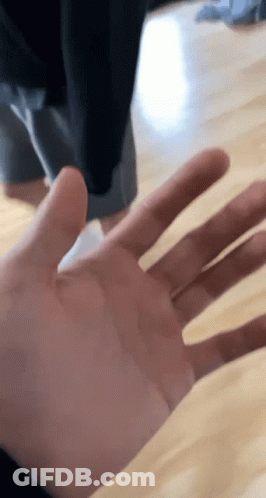 A Close Up Of A Person 'S Hand Reaching Out Towards The Camera GIF