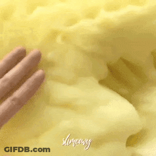 A Close Up Of A Person 'S Hand Touching A Yellow Blanket . GIF