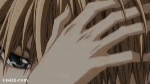 A Close Up Of A Person 'S Hand Touching Their Hair . GIF