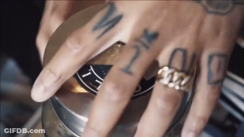 A Close Up Of A Person 'S Hand With Tattoos And A Ring GIF