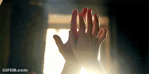 A Close Up Of A Person 'S Hands Giving Each Other A High Five In Front Of A Window . GIF