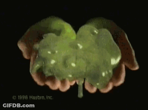 A Close Up Of A Person 'S Hands Holding A Green Substance That Says 1996 Hasbro Inc. GIF