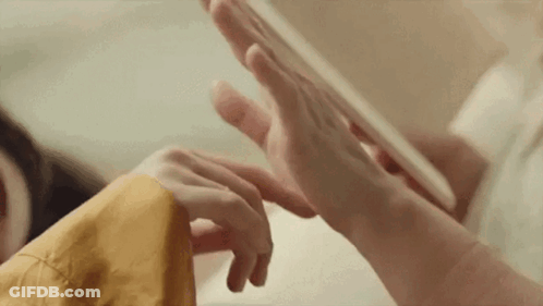 A Close Up Of A Person 'S Hands Playing With A Tablet . GIF
