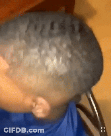 A Close Up Of A Person 'S Head With A Blue Shirt On GIF