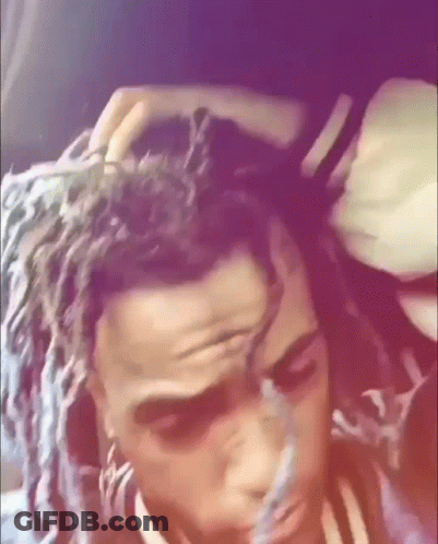 A Close Up Of A Person 'S Head With Dreadlocks And A Purple Background . GIF