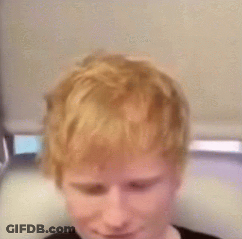 A Close Up Of A Person 'S Head With Red Hair And A Black Shirt . GIF