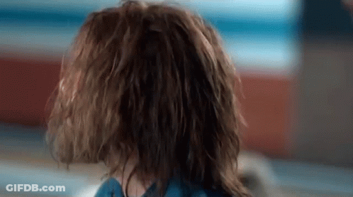 A Close Up Of A Person 'S Head With Wet Hair And A Blue Shirt . GIF