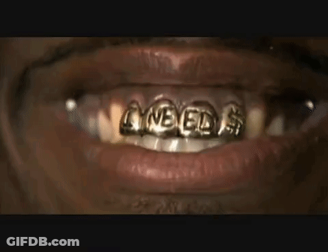 A Close Up Of A Person 'S Mouth With Gold Teeth Grills On It . GIF