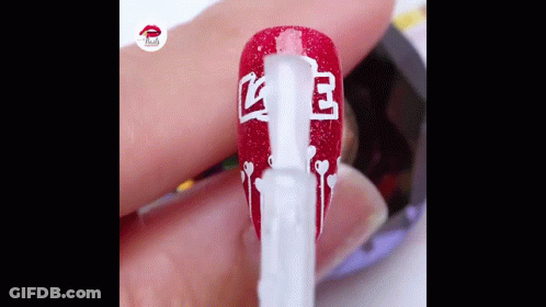 A Close Up Of A Person 'S Nails Being Painted With Red And White Polish . GIF