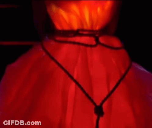 A Close Up Of A Person 'S Neck With A Red Light Behind It . GIF