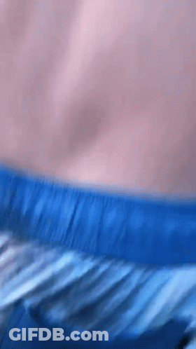 A Close Up Of A Person 'S Torso With Blue Shorts On GIF
