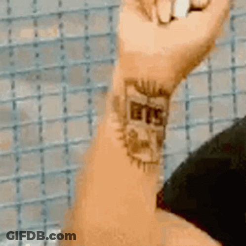 A Close Up Of A Person 'S Wrist With A Tattoo That Says BTS GIF