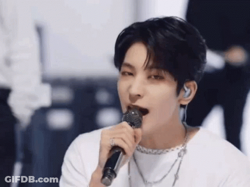 A Close Up Of A Person Singing Into A Microphone . GIF
