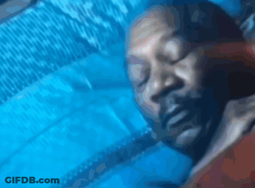 A Close Up Of A Person Sleeping On A Blue Blanket GIF