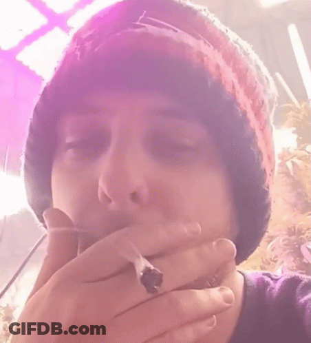 A Close Up Of A Person Wearing A Beanie And A Purple Shirt GIF