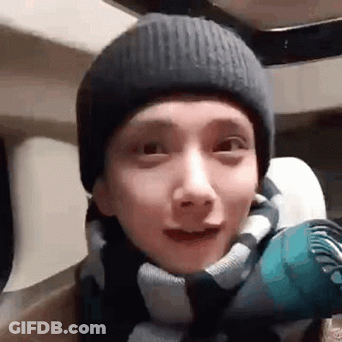 A Close Up Of A Person Wearing A Beanie And A Scarf . GIF