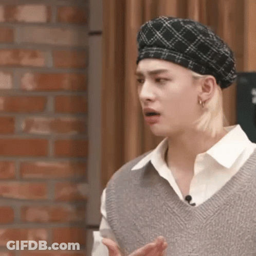 A Close Up Of A Person Wearing A Beret And A Sweater Vest . GIF