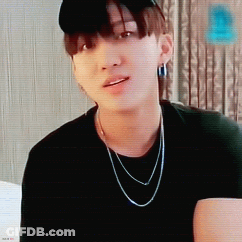 A Close Up Of A Person Wearing A Black Hat And A Necklace GIF