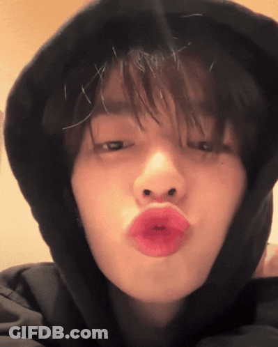 A Close Up Of A Person Wearing A Black Hoodie Making A Kissing Face GIF