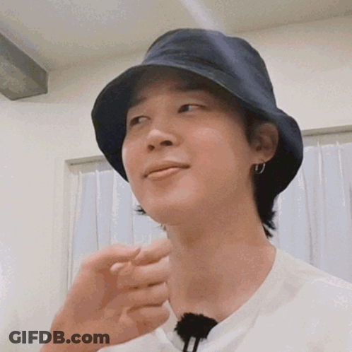 A Close Up Of A Person Wearing A Bucket Hat And Earrings . GIF