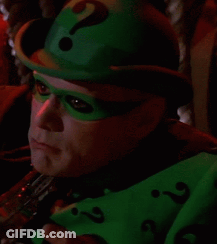 A Close Up Of A Person Wearing A Green Hat And Mask With A Question Mark . GIF