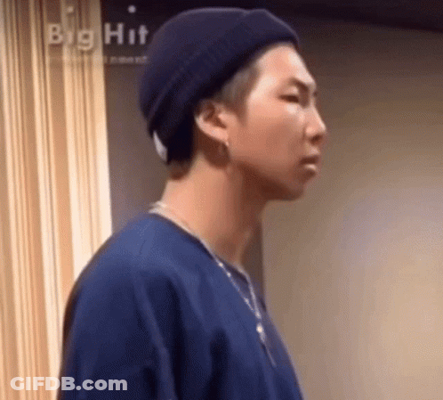 A Close Up Of A Person Wearing A Hat And A Necklace . GIF