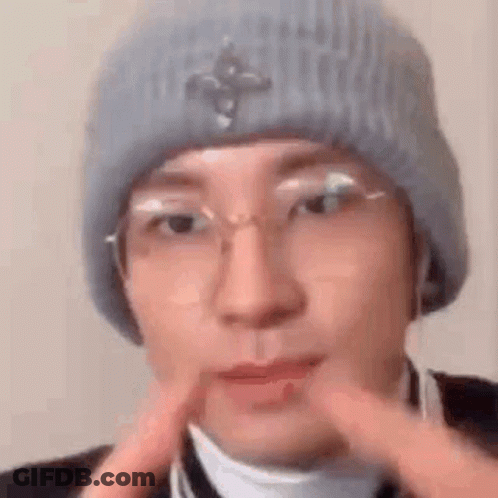 A Close Up Of A Person Wearing A Hat And Glasses . GIF