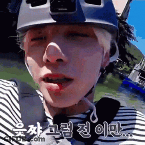 A Close Up Of A Person Wearing A Helmet And A Striped Shirt With Chinese Writing On It . GIF