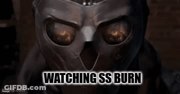 A Close Up Of A Person Wearing A Mask With The Words `` Watching Ss Burn '' Written Above It . GIF