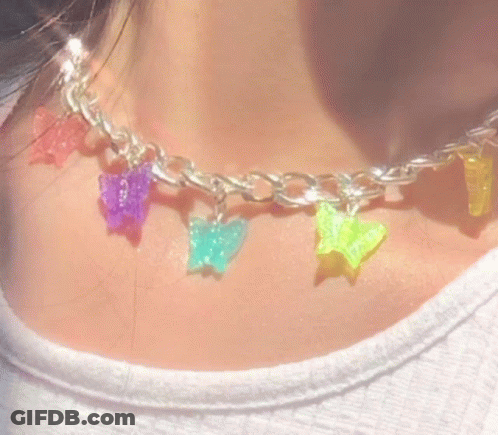 A Close Up Of A Person Wearing A Necklace With Colorful Butterflies And Stars . GIF