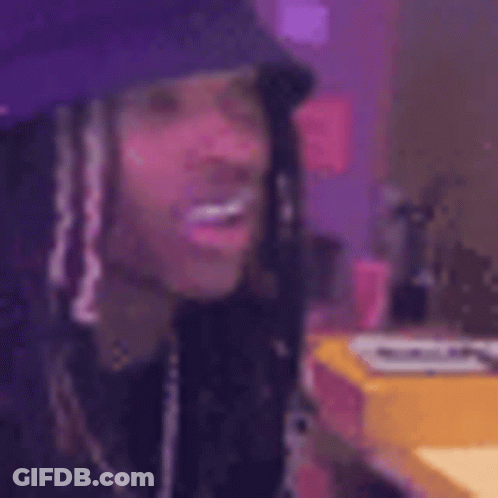 A Close Up Of A Person Wearing A Purple Hat And Dreadlocks . GIF