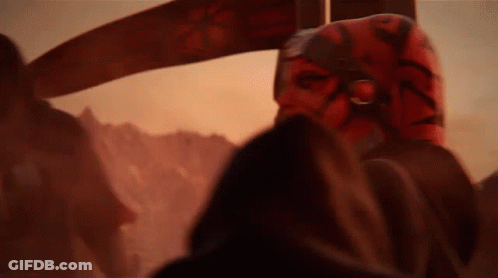 A Close Up Of A Person Wearing A Red Mask In A Dark Room . GIF