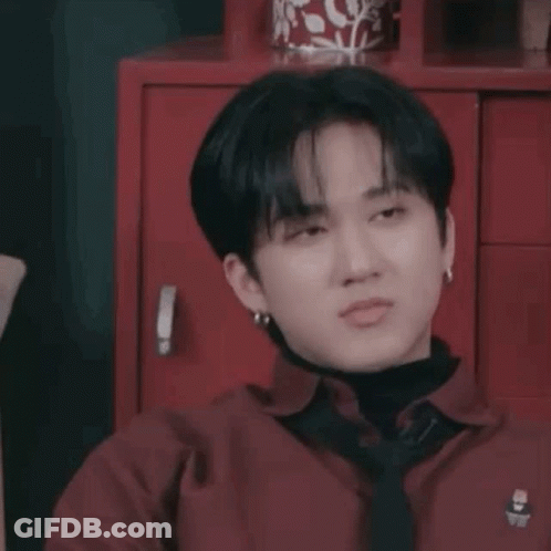 A Close Up Of A Person Wearing A Red Shirt And Tie Making A Funny Face . GIF