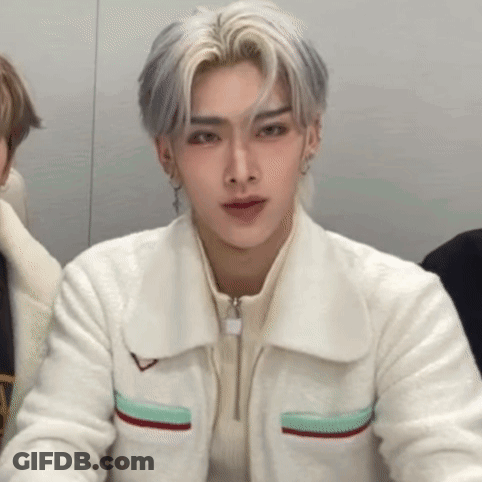 A Close Up Of A Person Wearing A White Jacket And Earrings . GIF