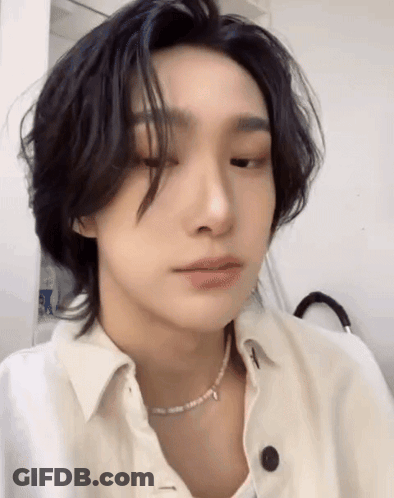 A Close Up Of A Person Wearing A White Shirt And A Pearl Necklace . GIF