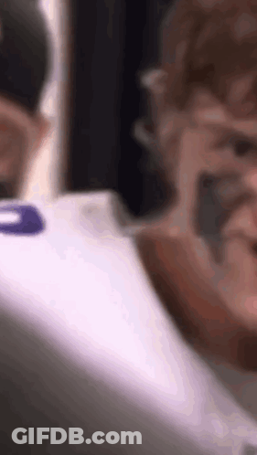 A Close Up Of A Person Wearing A White Shirt With A Purple Number On The Back . GIF