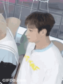 A Close Up Of A Person Wearing A White T-Shirt And A Blue Collar . GIF