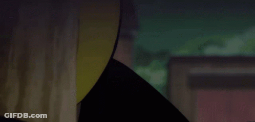 A Close Up Of A Person Wearing A Yellow Hat In A Dark Room GIF